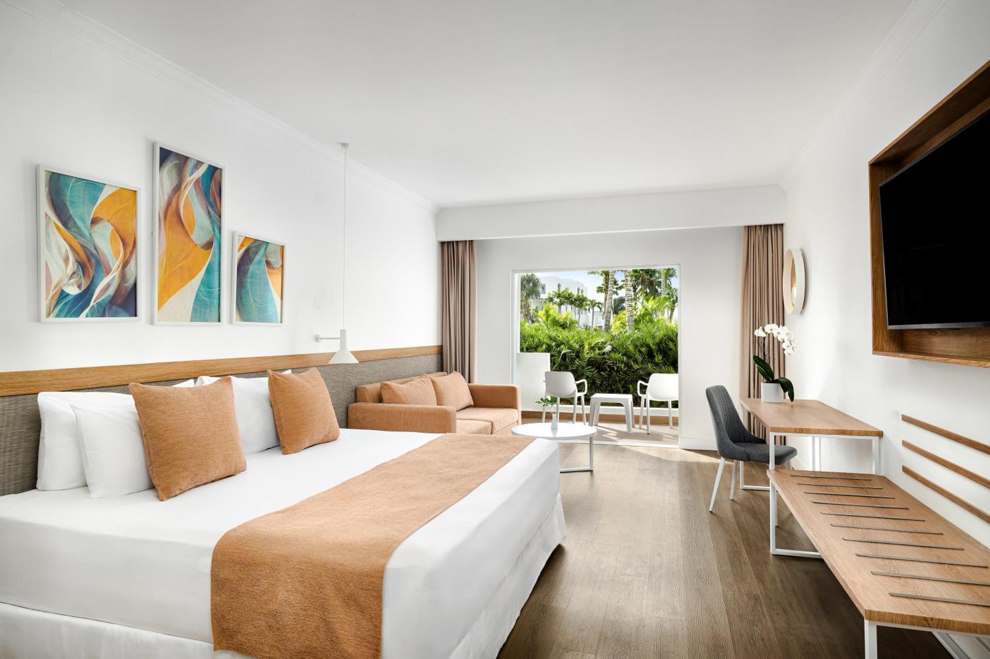 Deluxe Zimmer mit Kingsize-Bett und Blick auf die tropische Landschaft