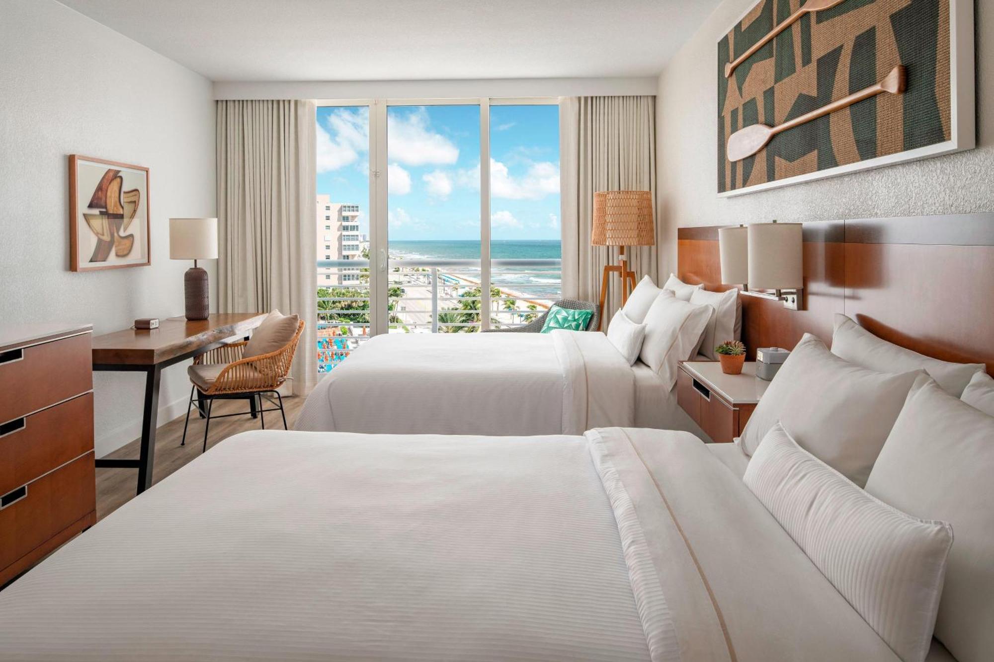 Quarto com 2 Camas de Casal e Vista Parcial do Mar