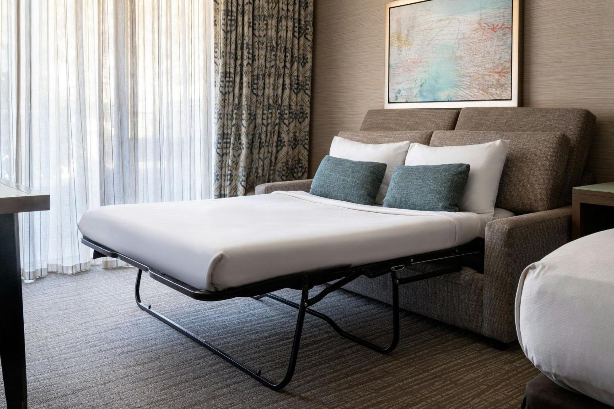 Habitación con 1 cama extragrande, sofá cama y vistas a la bahía
