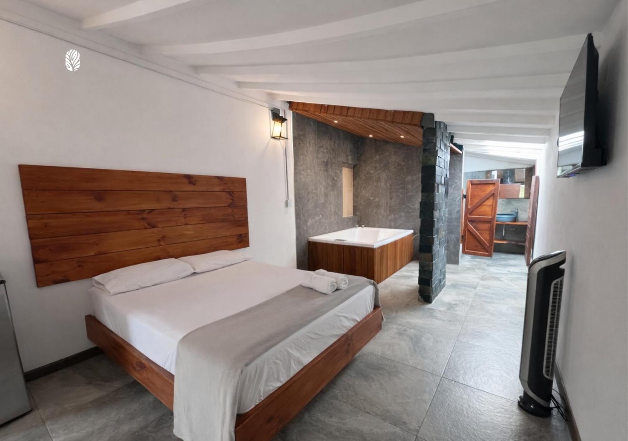 Habitación con cama grande y bañera de hidromasaje